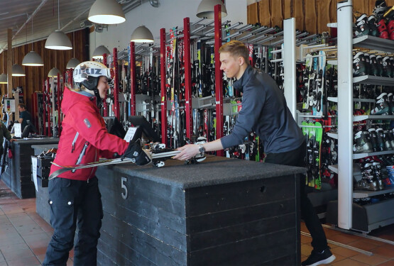 Kvinna hämtar ut skidor i skiduthyrningen.